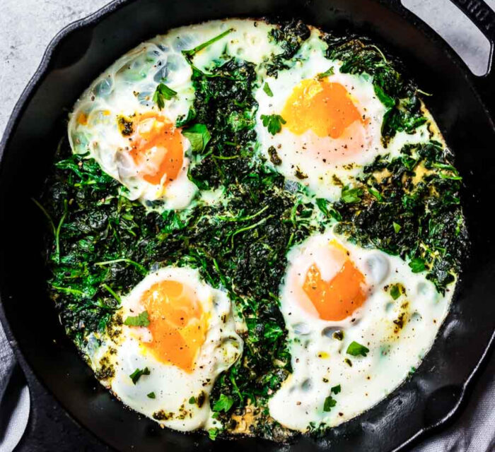 Des œufs avec des légumes cuits ensemble dans une poêle noire