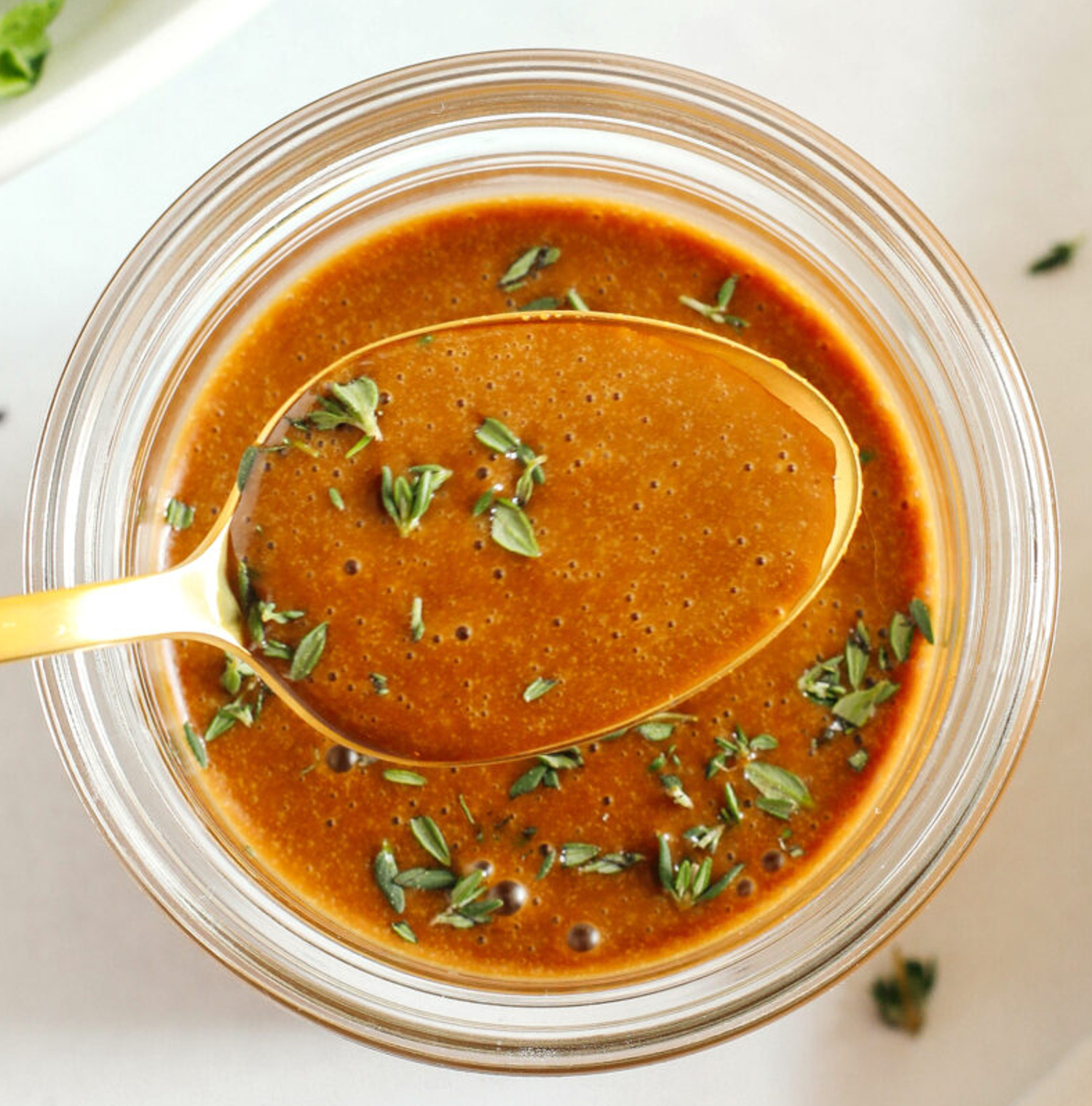 sauce avec du vinaigre et des herbes dans un pot avec une cuillère