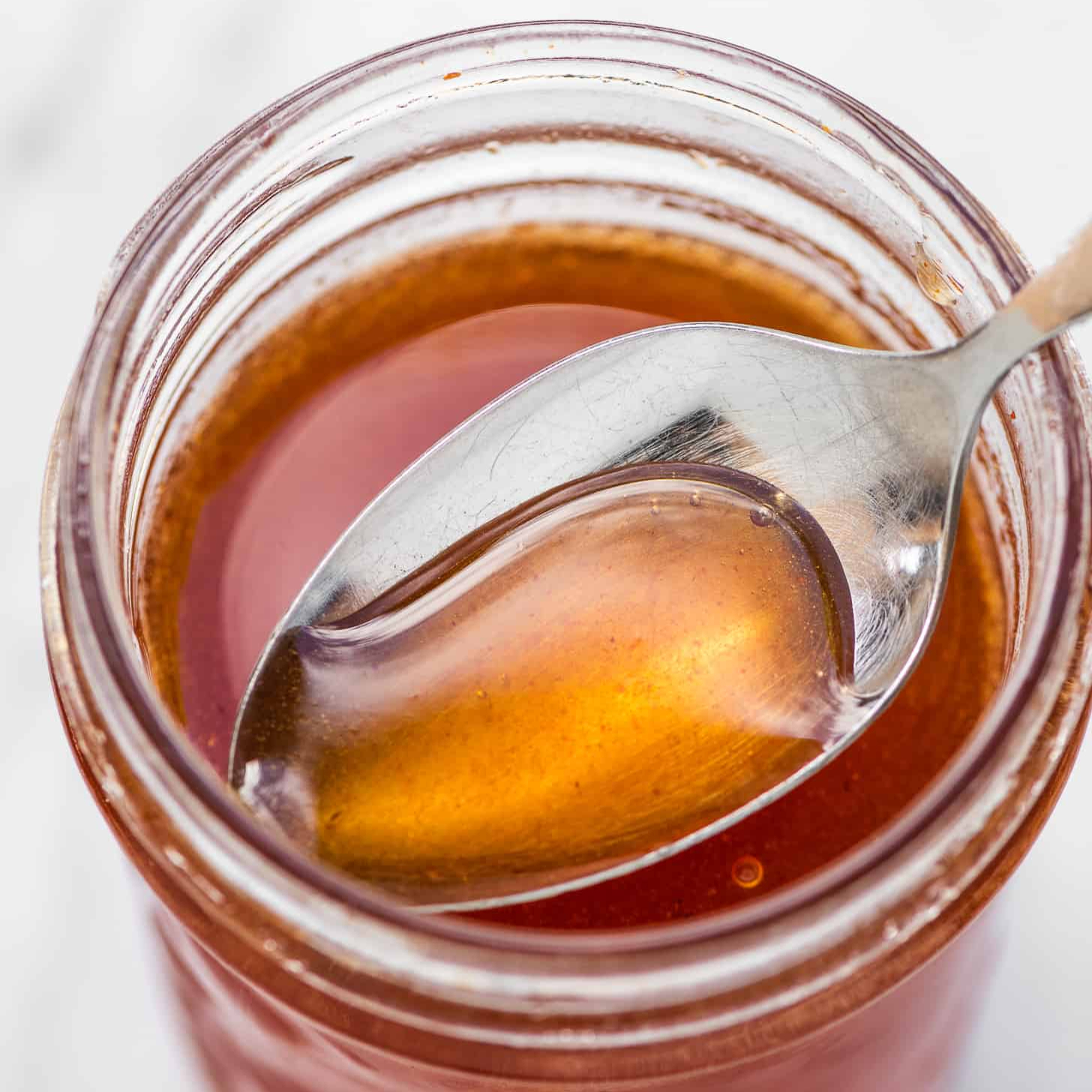 vinaigrette au miel dans un pot en verre avec une cuillère 