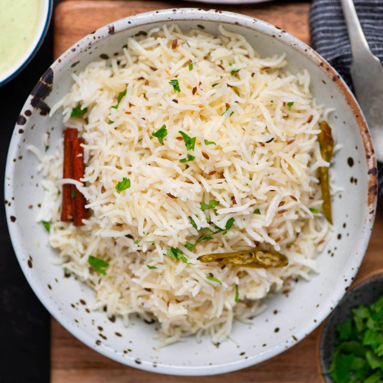 riz indien au cumin servi avec de la coriandre et autres épices dans un bol